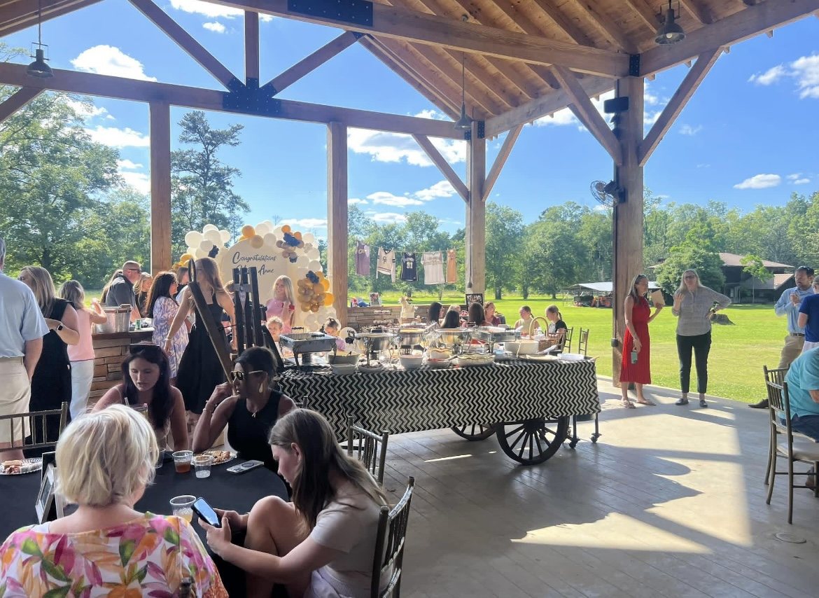 A party under the pavilion — balloon arch, buffet on the antique wagon, guests at the tables